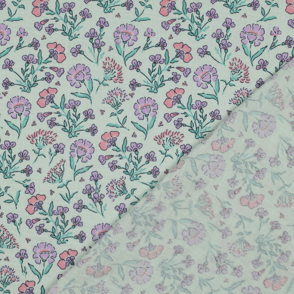 Detailaufnahme des Musselins mit zarten Wiesenblumen in Rosa, Flieder und Mintgrün auf mintfarbenem Untergrund