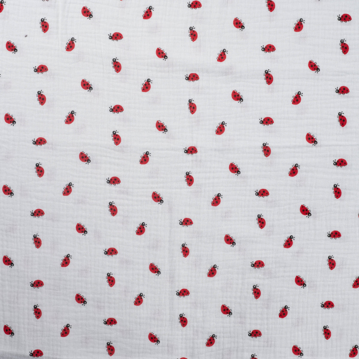 Detailaufnahme des Musselins in Off White mit Marienkäfern