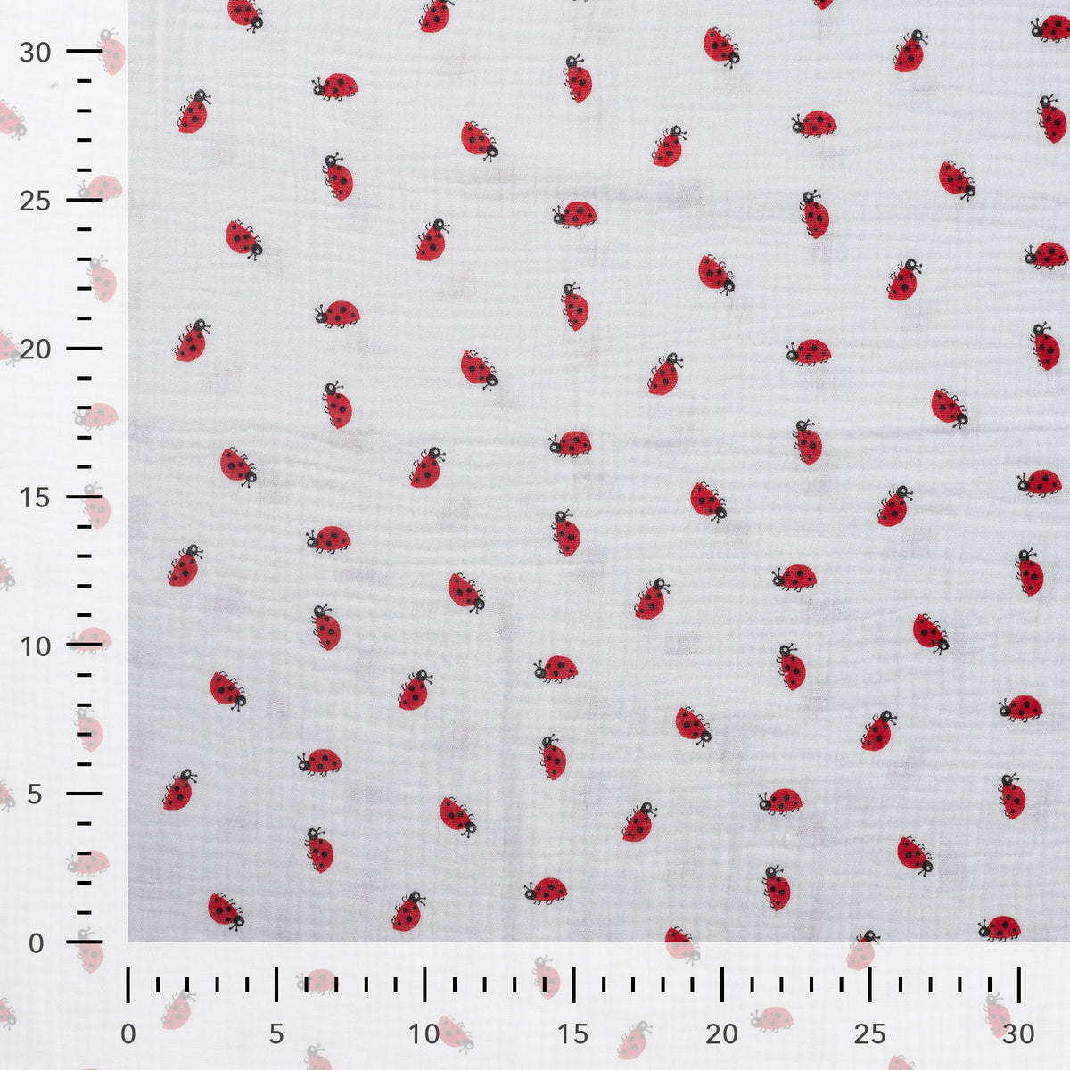 Detailaufnahme des Musselins in Off White mit Marienkäfern