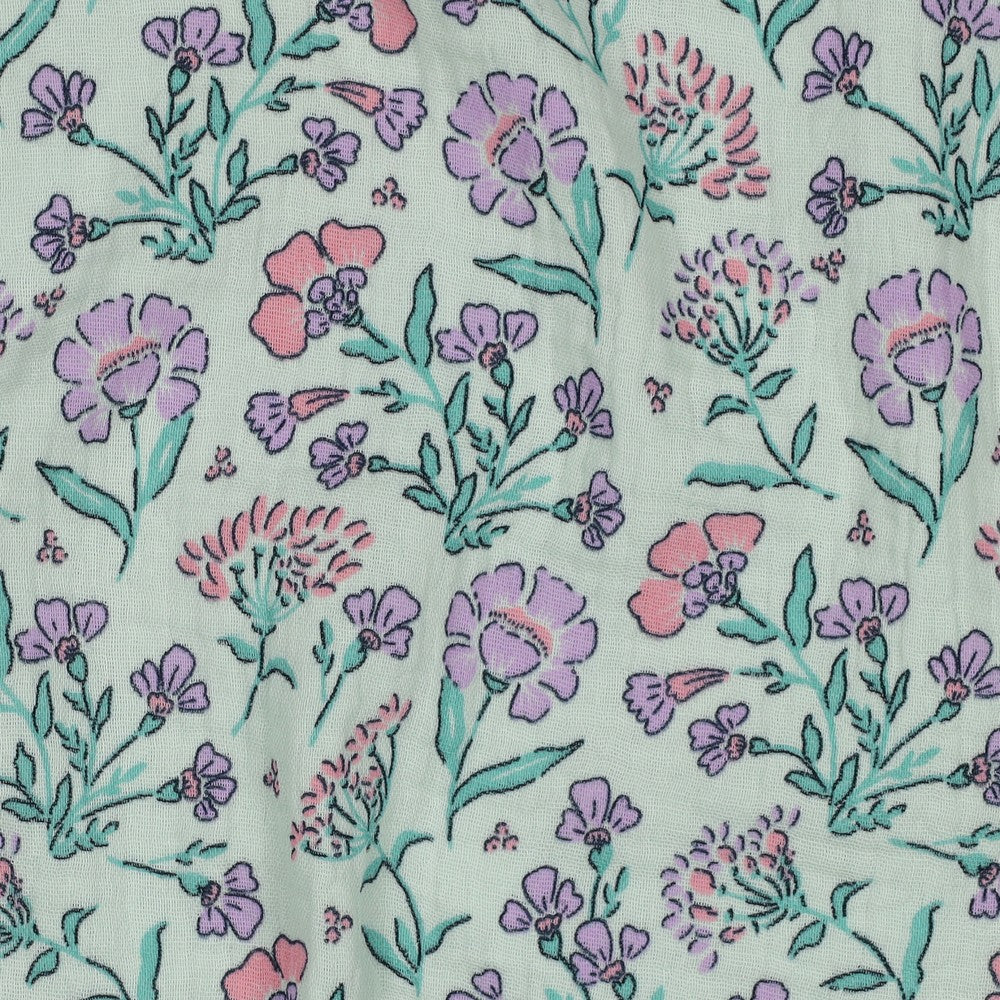 Detailaufnahme des Musselins mit zarten Wiesenblumen in Rosa, Flieder und Mintgrün auf mintfarbenem Untergrund