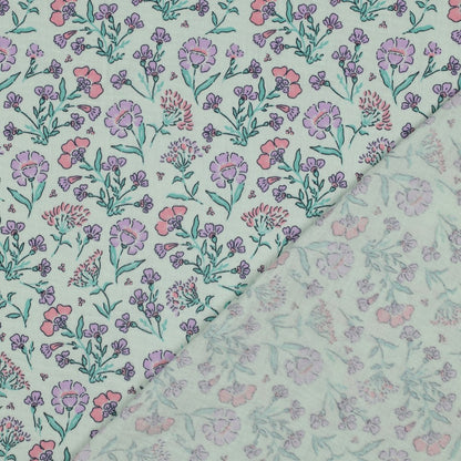 Detailaufnahme des Musselins mit zarten Wiesenblumen in Rosa, Flieder und Mintgrün auf mintfarbenem Untergrund