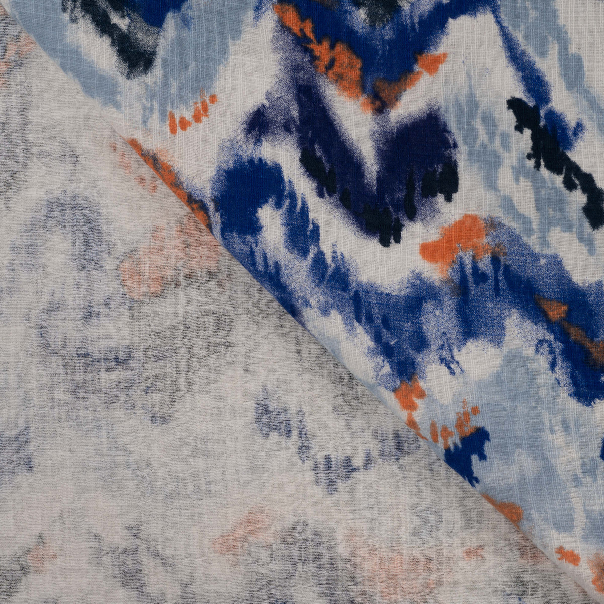 Detailaufnahme des Slub Musselins mit Aquarellmuster in Blau- und Rosttönen sowie charakteristischer Slub-Struktur